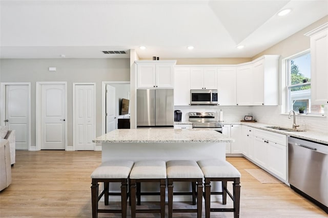 430 Baker Ave, Lake Helen, FL 32744 - kitchen with appliances with stainless steel finishes, a kitchen bar, recessed lighting, a center island, and decorative backsplash