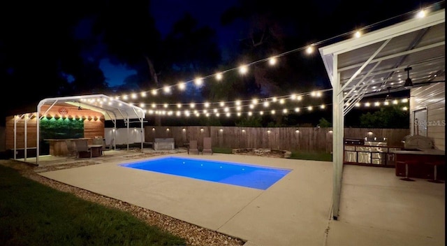 430 Baker Ave, Lake Helen, FL 32744 - pool at night with exterior kitchen, a patio, and a fenced backyard