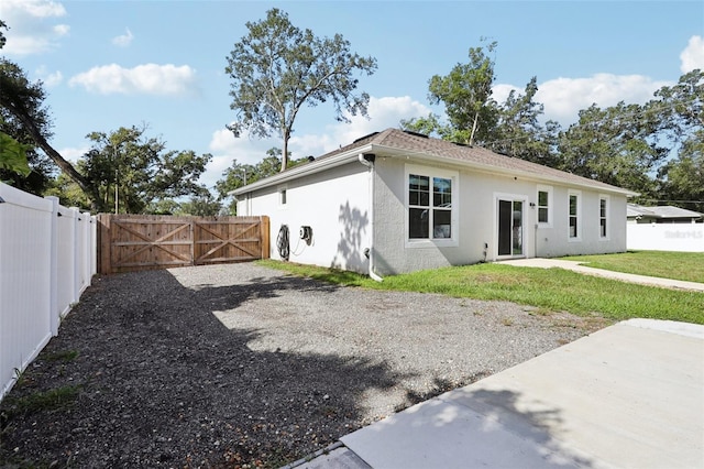 430 Baker Ave, Lake Helen, FL 32744 - rear view of house with stucco siding, a gate, a fenced backyard, and a patio area