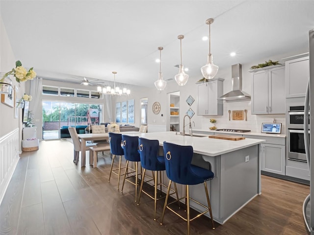 14903 Ellingsworth Ln, Winter Garden, FL 34787 - kitchen with wall chimney range hood, light countertops, dark wood-type flooring, a center island with sink, and recessed lighting