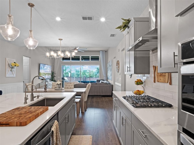 14903 Ellingsworth Ln, Winter Garden, FL 34787 - kitchen with stainless steel appliances, wall chimney range hood, gray cabinets, open floor plan, and recessed lighting