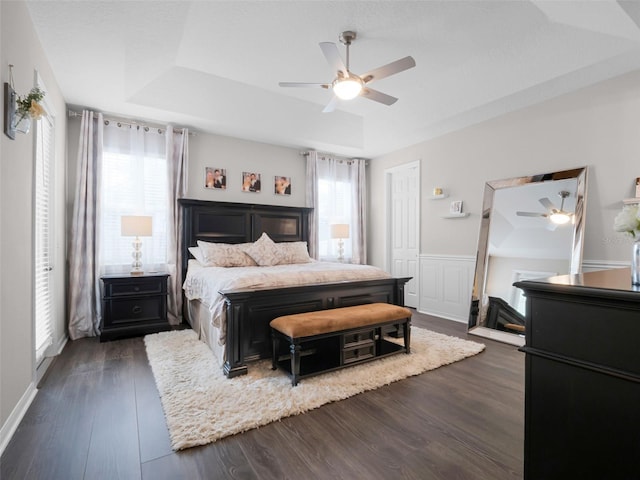 14903 Ellingsworth Ln, Winter Garden, FL 34787 - bedroom with a tray ceiling, dark wood-type flooring, a ceiling fan, and wainscoting