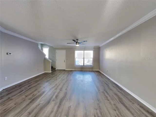 1709 Shady Ridge Ct Unit 243, Orlando, FL 32807 - unfurnished living room featuring a ceiling fan, wood finished floors, ornamental molding, a textured ceiling, and stairway