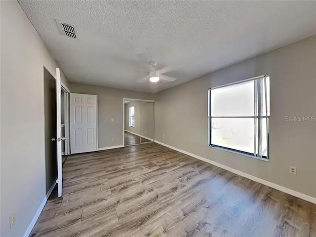 1709 Shady Ridge Ct Unit 243, Orlando, FL 32807 - unfurnished bedroom featuring a textured ceiling, wood finished floors, and a ceiling fan