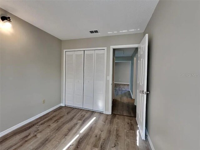 1709 Shady Ridge Ct Unit 243, Orlando, FL 32807 - unfurnished bedroom with wood finished floors and a closet
