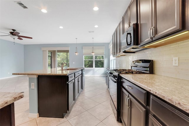 7540 Bishop Square Dr, Winter Garden, FL 34787 - kitchen featuring black appliances, ceiling fan, backsplash, dark brown cabinets, and a center island with sink