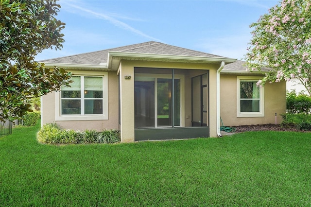 7540 Bishop Square Dr, Winter Garden, FL 34787 - back of property with stucco siding, a yard, roof with shingles, and a sunroom