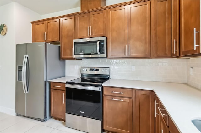 17461 Back Bay Ct, Clermont, FL 34714 - kitchen featuring stainless steel appliances, light countertops, brown cabinets, and backsplash