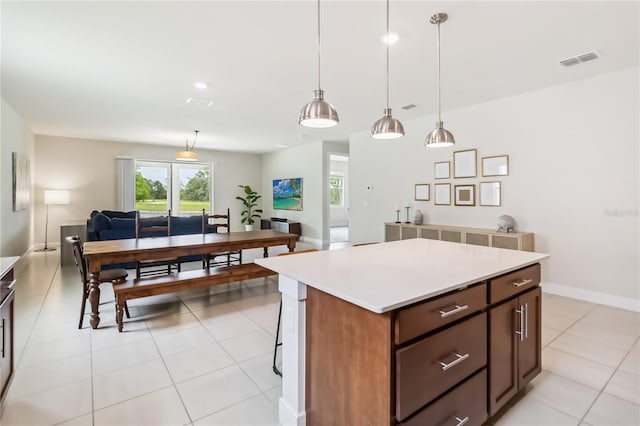 17461 Back Bay Ct, Clermont, FL 34714 - kitchen with light countertops, a kitchen island, light tile patterned floors, pendant lighting, and open floor plan