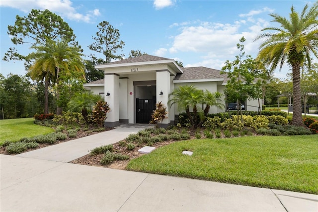 17461 Back Bay Ct, Clermont, FL 34714 - view of front of house with stucco siding, a front yard, and a shingled roof