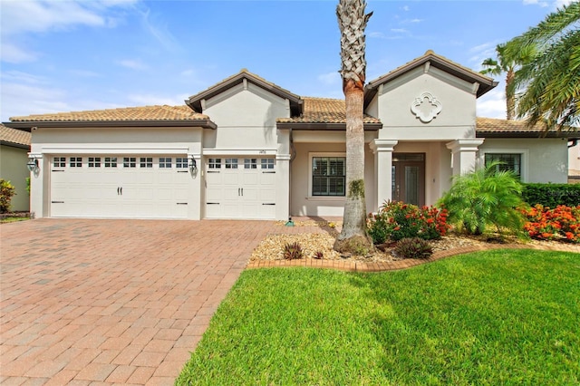 1406 Deuce Cir, Champions Gate, FL 33896 - mediterranean / spanish-style home with decorative driveway, a garage, stucco siding, a front lawn, and a tile roof