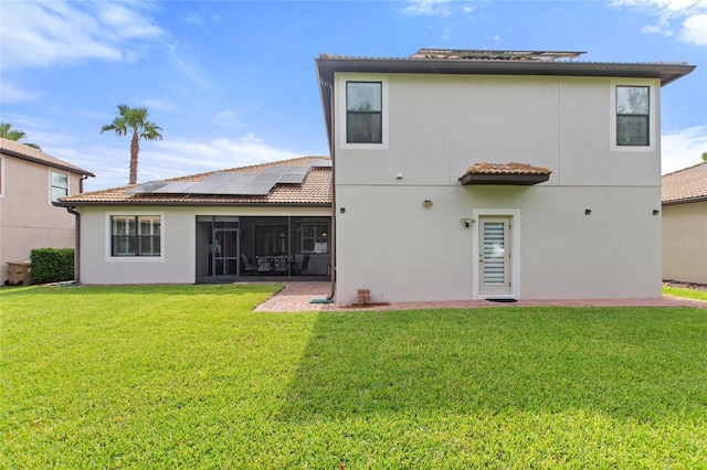 1406 Deuce Cir, Champions Gate, FL 33896 - rear view of property featuring a sunroom, a lawn, stucco siding, roof mounted solar panels, and a tile roof