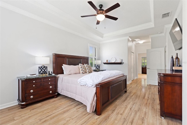 1406 Deuce Cir, Champions Gate, FL 33896 - bedroom featuring light wood-type flooring, a tray ceiling, crown molding, and a ceiling fan
