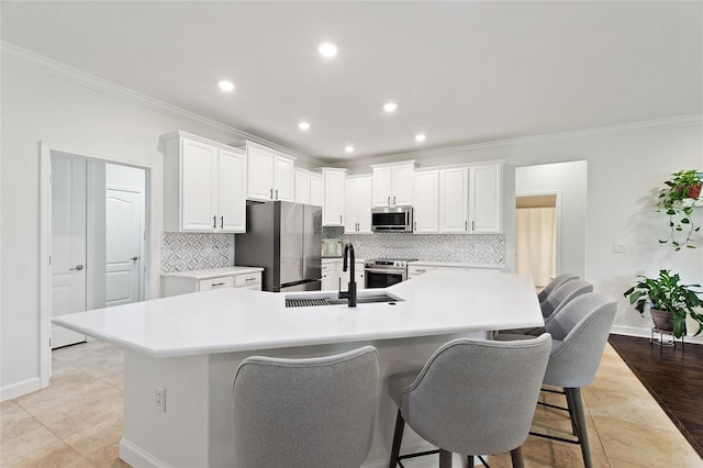 1406 Deuce Cir, Champions Gate, FL 33896 - kitchen with appliances with stainless steel finishes, crown molding, decorative backsplash, a breakfast bar area, and a spacious island