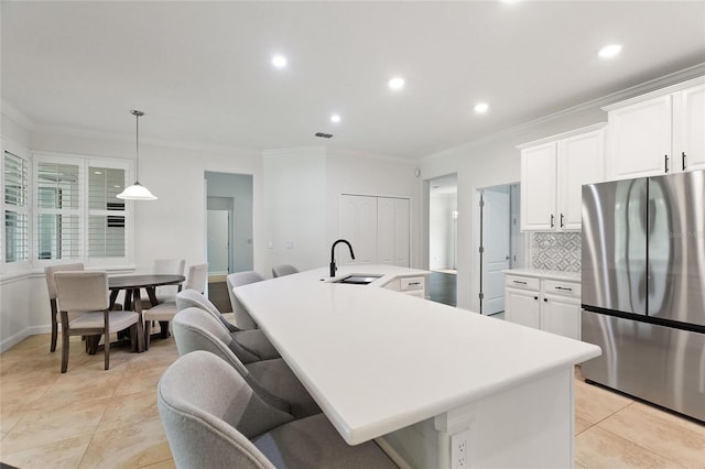 1406 Deuce Cir, Champions Gate, FL 33896 - kitchen with freestanding refrigerator, a large island, light countertops, crown molding, and white cabinets