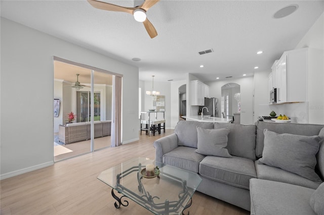 11222 Rapallo Ln, Windermere, FL 34786 - living room with a ceiling fan, arched walkways, healthy amount of natural light, light wood-style floors, and recessed lighting