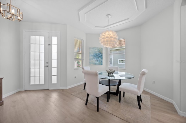 11222 Rapallo Ln, Windermere, FL 34786 - dining room featuring a chandelier, light wood-type flooring, and a tray ceiling