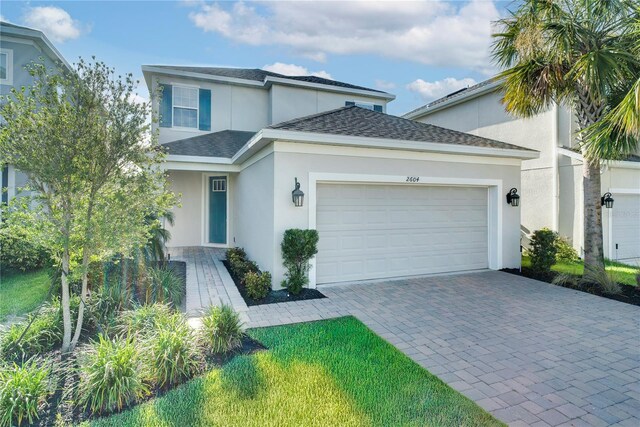 2604 Pinnacle, Clermont, FL 34711 - traditional home with stucco siding, an attached garage, roof with shingles, and decorative driveway