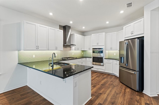 2604 Pinnacle, Clermont, FL 34711 - kitchen with appliances with stainless steel finishes, wall chimney exhaust hood, a peninsula, decorative backsplash, and dark wood-type flooring