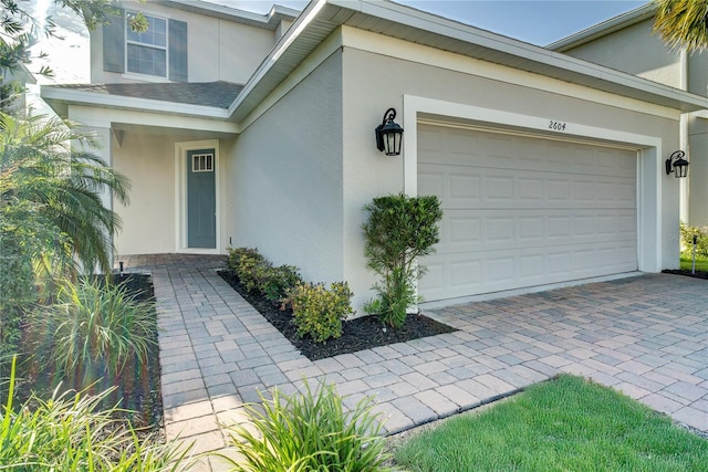2604 Pinnacle, Clermont, FL 34711 - entrance to property featuring stucco siding, an attached garage, and decorative driveway