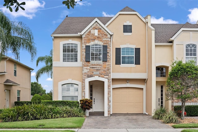1011 Wood Cv, Kissimmee, FL 34743 - view of front facade with stone siding, stucco siding, and decorative driveway