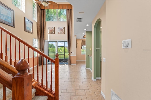 1011 Wood Cv, Kissimmee, FL 34743 - entryway with plenty of natural light, arched walkways, stone tile flooring, stairs, and a high ceiling