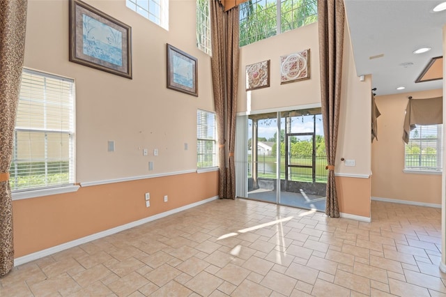 1011 Wood Cv, Kissimmee, FL 34743 - spare room with a towering ceiling and stone finish floors