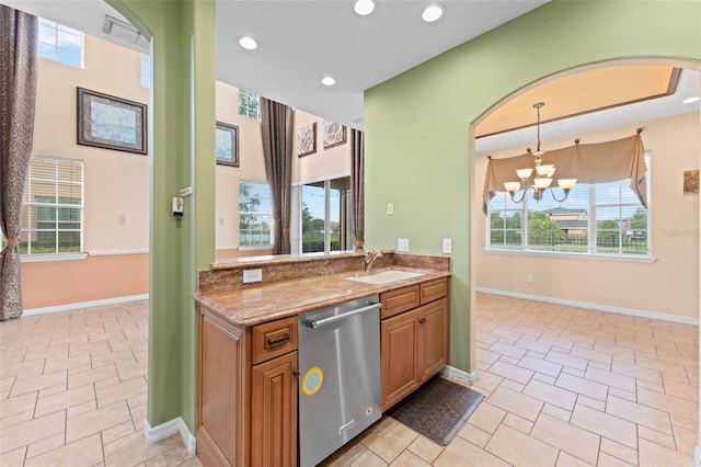 1011 Wood Cv, Kissimmee, FL 34743 - kitchen featuring dishwasher, arched walkways, light stone countertops, a chandelier, and recessed lighting