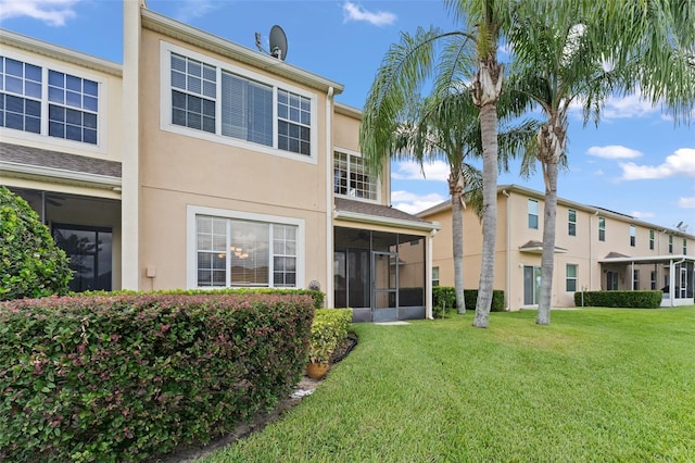 1011 Wood Cv, Kissimmee, FL 34743 - back of property with a sunroom, a lawn, and stucco siding