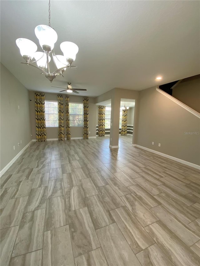 8512 Player Point Dr, Davenport, FL 33896 - unfurnished living room featuring a chandelier, ceiling fan, and light wood-style flooring