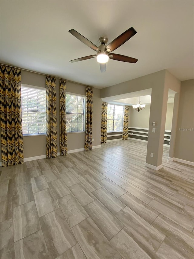 8512 Player Point Dr, Davenport, FL 33896 - unfurnished living room featuring a chandelier and ceiling fan