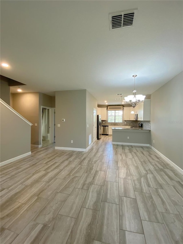 8512 Player Point Dr, Davenport, FL 33896 - unfurnished living room with a chandelier, light wood-type flooring, and recessed lighting
