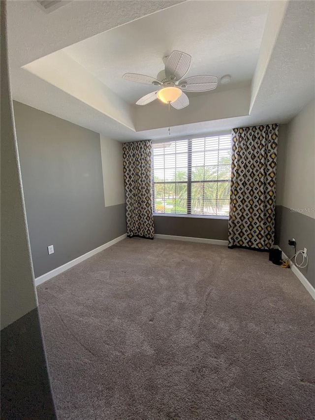8512 Player Point Dr, Davenport, FL 33896 - empty room featuring a tray ceiling, carpet, and ceiling fan