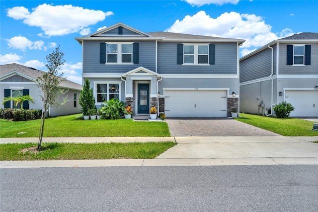 2912 Sanctuary Dr, Clermont, FL 34714 - view of front of home with decorative driveway, stone siding, a front yard, and an attached garage