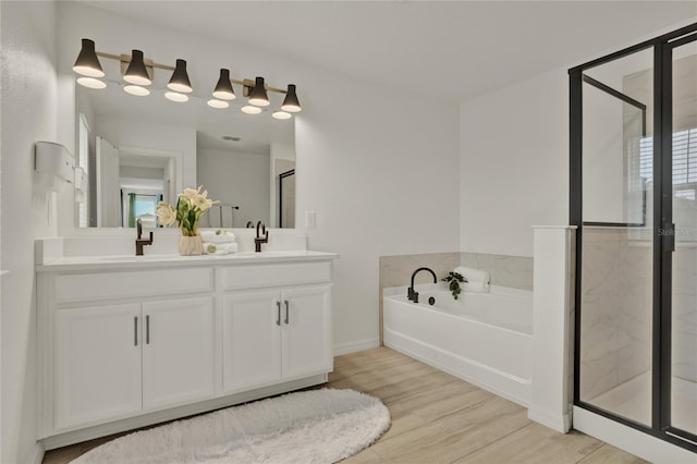 2912 Sanctuary Dr, Clermont, FL 34714 - bathroom with a shower stall, a bath, double vanity, and wood finished floors