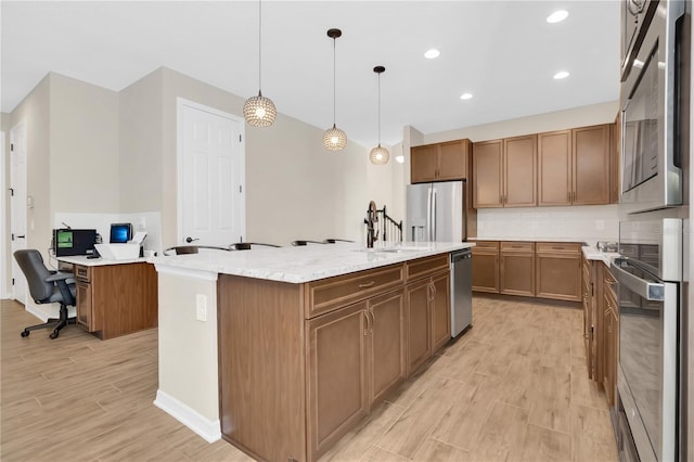 1564 Atlantic Coastline Loop, Oakland, FL 34787 - kitchen featuring appliances with stainless steel finishes, light wood-type flooring, an island with sink, backsplash, and recessed lighting