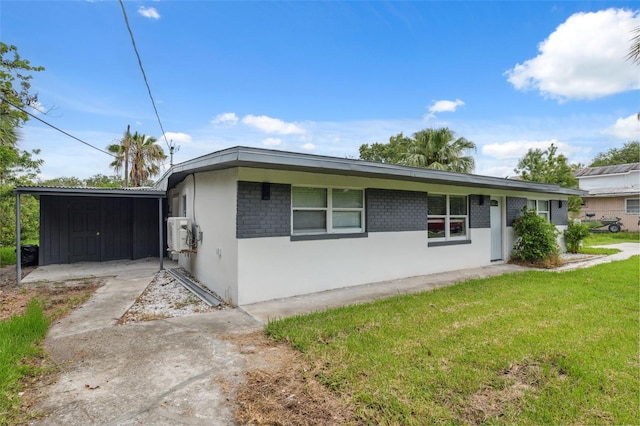 4505 Cottonwood Dr, New Port Richey, FL 34652 - view of front facade featuring a front yard, stucco siding, and a carport