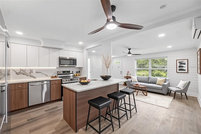 4505 Cottonwood Dr, New Port Richey, FL 34652 - kitchen with stainless steel appliances, modern cabinets, a breakfast bar, a ceiling fan, and white cabinets