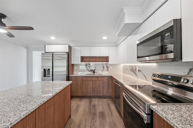 4505 Cottonwood Dr, New Port Richey, FL 34652 - kitchen with stainless steel appliances, modern cabinets, brown cabinets, crown molding, and recessed lighting
