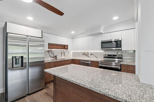 4505 Cottonwood Dr, New Port Richey, FL 34652 - kitchen with stainless steel appliances, ornamental molding, white cabinets, modern cabinets, and wood finished floors
