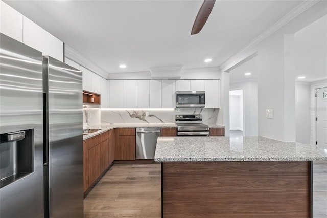 4505 Cottonwood Dr, New Port Richey, FL 34652 - kitchen featuring stainless steel appliances, modern cabinets, a ceiling fan, decorative backsplash, and white cabinetry