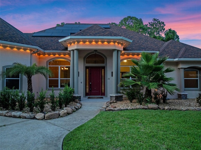 32 Allenwood Look, Ormond Beach, FL 32174 - mediterranean / spanish-style house with a lawn, stucco siding, roof mounted solar panels, and roof with shingles