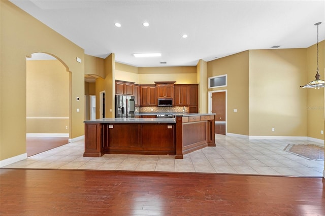32 Allenwood Look, Ormond Beach, FL 32174 - kitchen with appliances with stainless steel finishes, light wood finished floors, arched walkways, tasteful backsplash, and hanging light fixtures