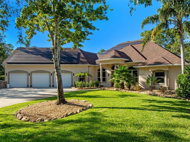 32 Allenwood Look, Ormond Beach, FL 32174 - view of front of property with stucco siding, an attached garage, concrete driveway, solar panels, and a front lawn