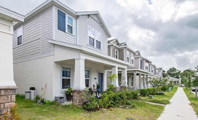 4152 Pino St, Apopka, FL 32712 - view of side of home with covered porch, stucco siding, and a residential view