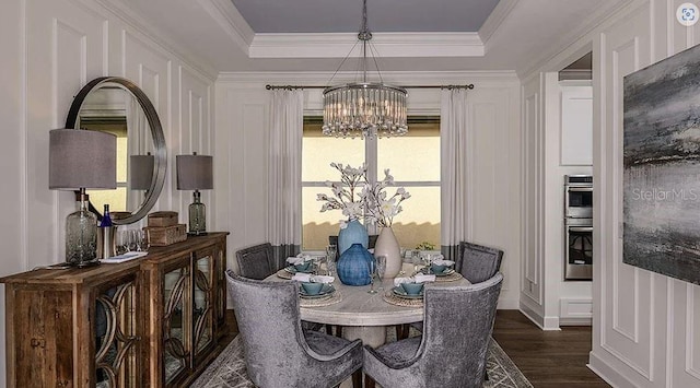 858 Arbor Green Trl, Saint Cloud, FL 34771 - dining space featuring a chandelier, dark wood-type flooring, ornamental molding, a raised ceiling, and a decorative wall