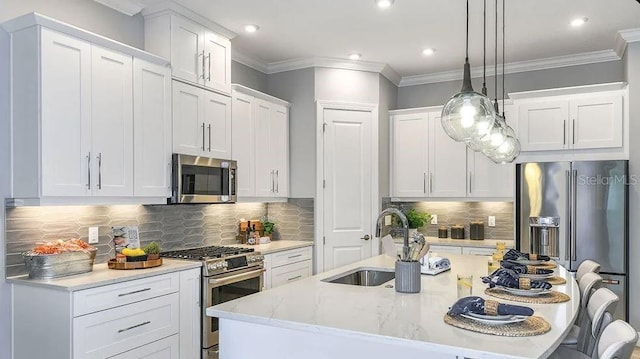858 Arbor Green Trl, Saint Cloud, FL 34771 - kitchen with appliances with stainless steel finishes, a center island with sink, a breakfast bar area, crown molding, and white cabinetry