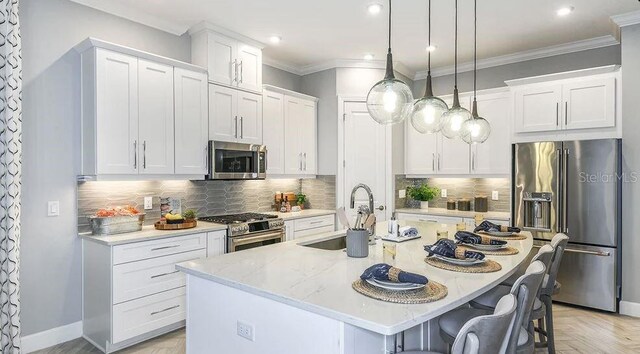 858 Arbor Green Trl, Saint Cloud, FL 34771 - kitchen with high quality appliances, an island with sink, a breakfast bar, white cabinetry, and recessed lighting