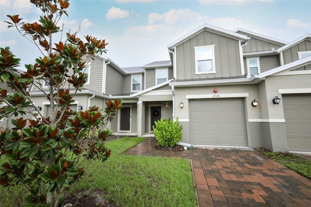 2326 Carrabelle Way, Sanford, FL 32771 - townhome / multi-family property featuring board and batten siding, decorative driveway, a garage, and stucco siding