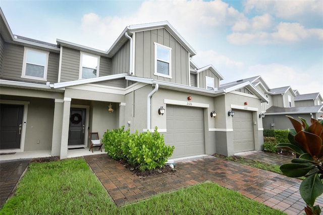 2326 Carrabelle Way, Sanford, FL 32771 - townhome / multi-family property with board and batten siding, stucco siding, an attached garage, and decorative driveway